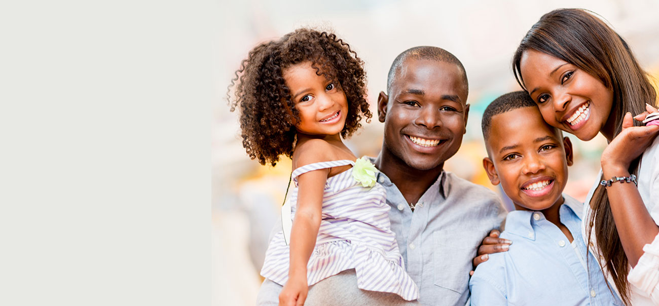 Family of four smiling after first visit to Tysons Corner Dentists