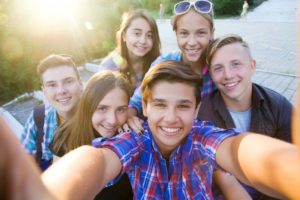 group of teenagers taking a selfie together 